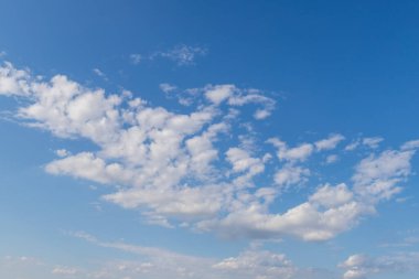 Güneşli havada beyaz bulutlu mavi gökyüzü.