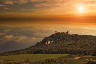 The ruins of the Devicky castle in the Palava region in South Moravia in the Czech Republic. There are clouds in the sky at sunset. clipart