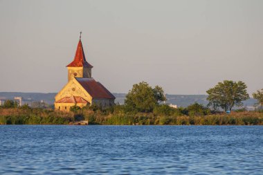 St. Linhart Kilisesi, karakteristik kırmızı çatısı ve kulesi olan Romanesk-Gotik bir bina, fotoğrafın merkezinde yer alıyor.. 