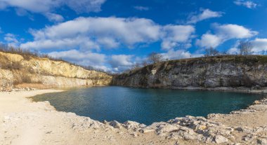 Çek Cumhuriyeti 'ndeki Mikulov yakınlarında terk edilmiş Janicuv Vrch kireç taşı ocağının manzarası. Taş ocağı zeminini kısmen su basmış. Bu da kendine özgü turkuaz ve mavi suları olan sakin bir göl oluşturuyor.