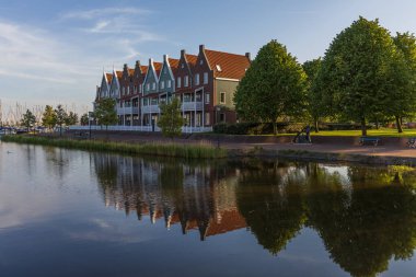 Volendam 'ın su yüzeyine yansıyan görkemli gable evleri. Kuzey Hollanda, Hollanda 'da huzurlu bir bahar günü-