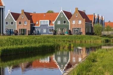 Volendam 'da sakin bir kanala yansıyan renkli gable evler. Hollanda 'nın Kuzey Hollanda eyaletinde geleneksel Hollanda mimarisi.