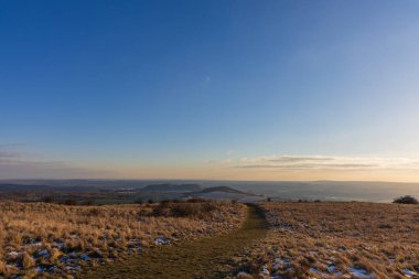 Mikulov ve Palava manzaralı Table Dağı 'nda yürüyüş yolu. Gün batımında kar ve geniş ufuk tozuyla kış manzarası.