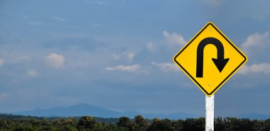 Bulutlu ve mavi arkaplanlı U-dönüş işareti.