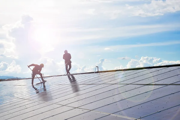 Binanın çatısına güneş ışığından gelen temiz ve yeşil enerjiyi kullanmak için fotovoltaik paneller yerleştirildi. İşçiler, güvercin dışkısı ve tozu yüzünden yüzeyi yıkıyor ve temizliyor..