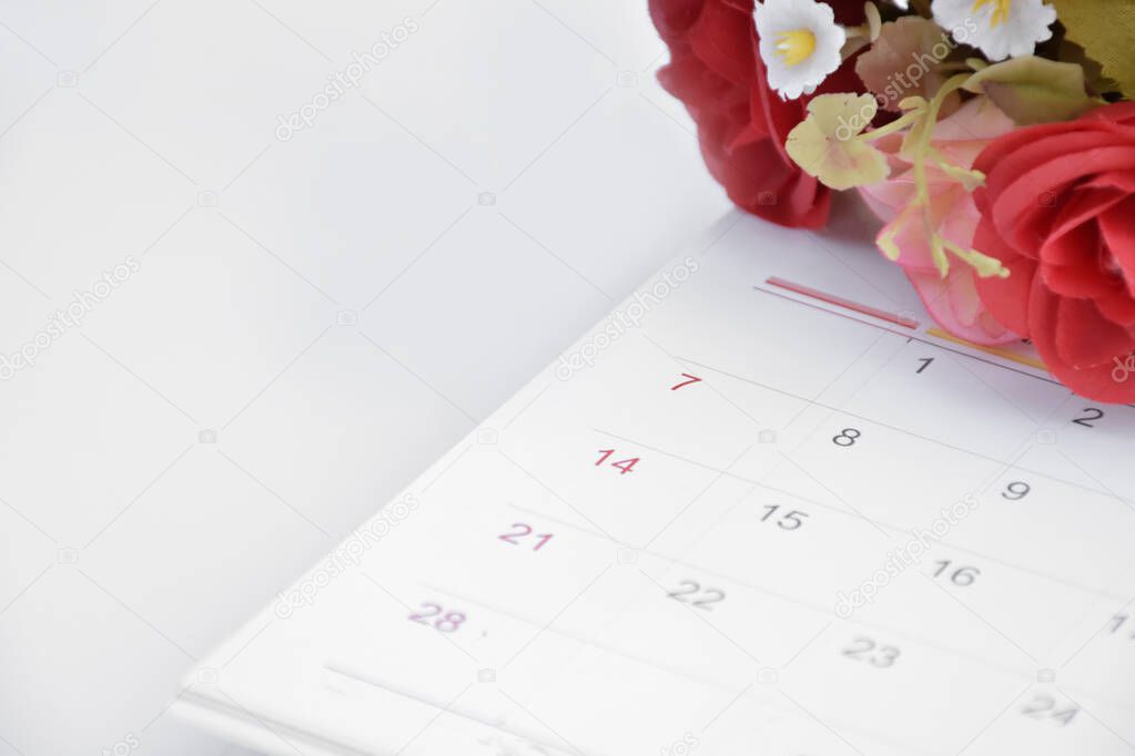 White desk calendar of February with rose flower, concept for valentines day on 14th February 2021.