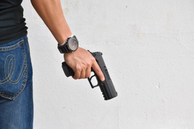 Otomatik siyah 9 mm 'lik tabanca hedefe, soygun konseptine, gangstere, güvenliğe ve dünya çapında atış sporlarına yönelik tetiği çekmeye hazır..