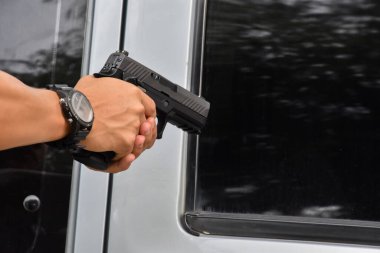 Otomatik siyah 9 mm 'lik tabanca hedefe, soygun konseptine, gangstere, güvenliğe ve dünya çapında atış sporlarına yönelik tetiği çekmeye hazır..