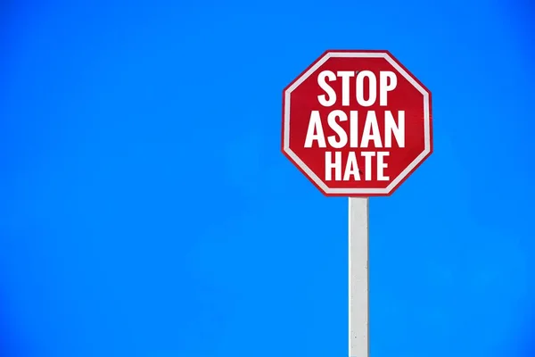 Traffic sign  \'Stop Asian Hate\' on pole, concept for calling international community to stop hating, hurting and harassing Asian people in the spreading of covid-19 crisis.