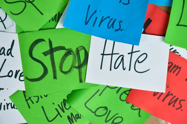 Word card \'Stop Hate.\' holding in hand, concept for calling international community to stop hating, hurting and harassing Asian people in the spreading of covid-19 crisis.