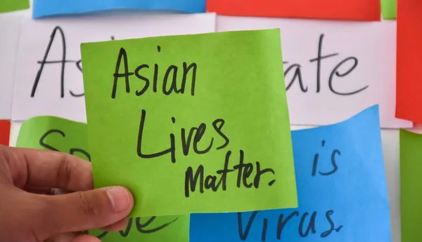 Word card \'Asian LIves Matter.\' holding in hand, concept for calling international community to stop hating, hurting and harassing Asian people in the spreading of covid-19 crisis.