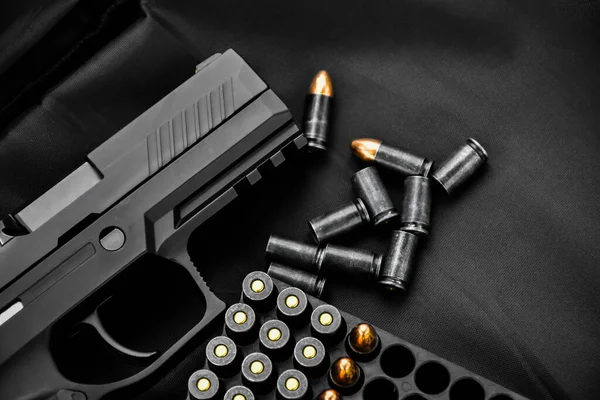 Automatic black 9mm pistol and bullet shells on black leather background, concept for robbery, bodygaurd, mafias, gangster, sefety and security around the world. clipping paths.