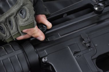 Otomatik siyah havalı silah ya da BBGUN mühimmatı silahlı adam tarafından kontrol ediliyordu. Seçici odaklanma, atış sporu ve güvenlik eğitimi konsepti.