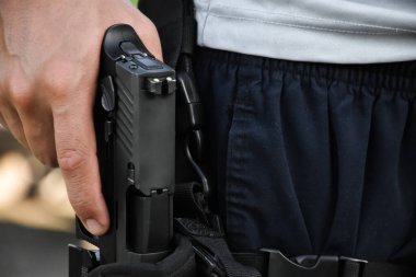 Otomatik 9mm 'lik tabanca kılıfına dayanıyor. Çekilmeye ve hedefe ateş etmeye hazır. Güvenlik mesleği kavramı ve dünya çapında atış sporu..