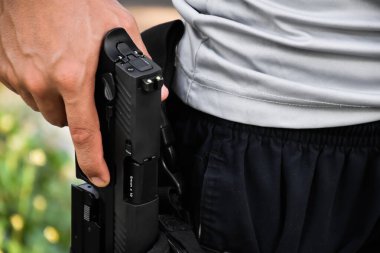 Otomatik 9mm 'lik tabanca kılıfına dayanıyor. Çekilmeye ve hedefe ateş etmeye hazır. Güvenlik mesleği kavramı ve dünya çapında atış sporu..