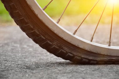 Patlak lastiği olan ve kaldırıma park etmiş arka planı bulanık motosiklet manzarası. Lastiğe yumuşak ve seçici odaklanma.