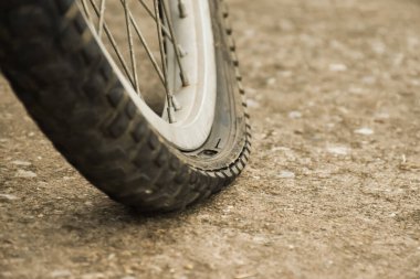 Patlak lastiği olan ve kaldırıma park etmiş arka planı bulanık motosiklet manzarası. Lastiğe yumuşak ve seçici odaklanma.