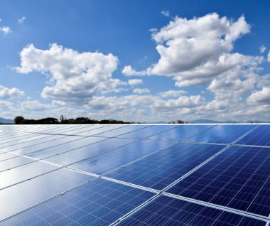 Binanın güneş çatısı, bulutlu ve mavimsi arka plan. Güneş panellerine yumuşak ve seçici odaklanma.