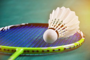 Badminton raketi ve badminton kortunda beyaz badminton topu. Mekik siki üzerine yumuşak ve seçici odaklanma.