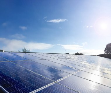 Binanın çatısına yerleştirilen fotovoltaik paneller, güneş ışığından elde edilen doğal enerjiyi depolama ve dünya üzerindeki insan çevresini önemsemek için kullanma kavramı.
