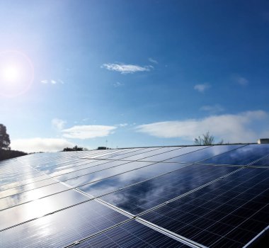 Binanın çatısına yerleştirilen fotovoltaik paneller, güneş ışığından elde edilen doğal enerjiyi depolama ve dünya üzerindeki insan çevresini önemsemek için kullanma kavramı.