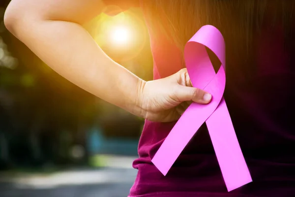 ピンクの紙のリボンは 女性の手の中に保持し 世界中の缶から病気である女性の乳癌と戦うために支援するための概念 柔らかくて選択的な焦点 — ストック写真