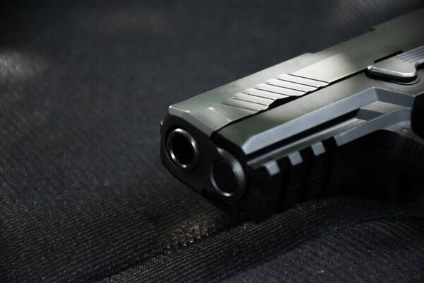 Closeup view of 9mm black pistol on black leather.