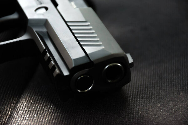 Closeup view of 9mm black pistol on black leather.