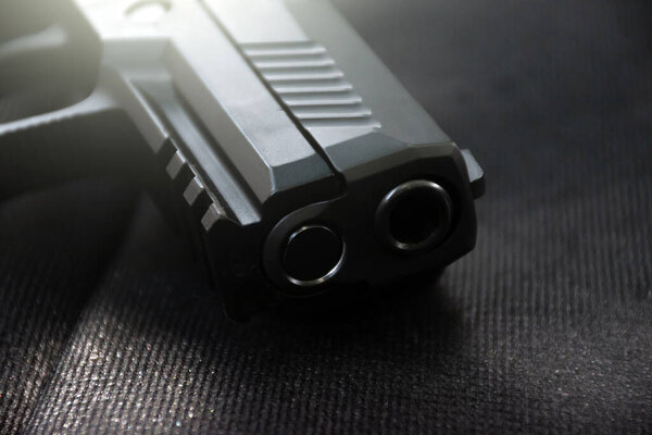 Closeup view of 9mm black pistol on black leather.