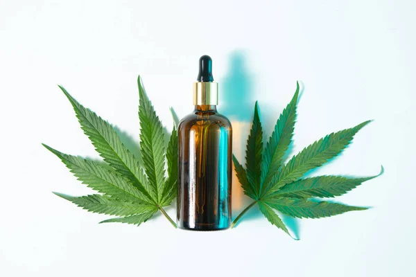 Glass jar of CBD natural product and hemp leaves in neon light, top view — Stock Photo, Image