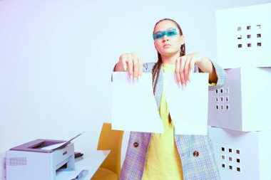 Yazıcı ve kutuların yanında yırtık kağıtları olan Asyalı şık bir ofis çalışanı. Renkli Neon ışığı