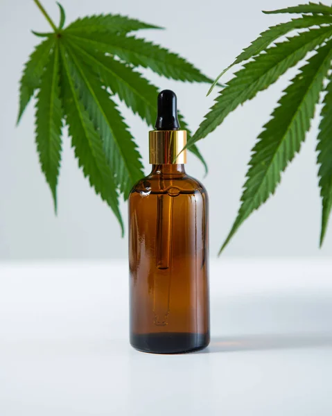 Glas mall burk med CBD cannabis produkt med hampa blad på grå bakgrund, närbild — Stockfoto
