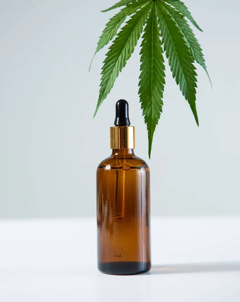Glas mall burk med CBD cannabis produkt och hampa blad på grå bakgrund, närbild — Stockfoto