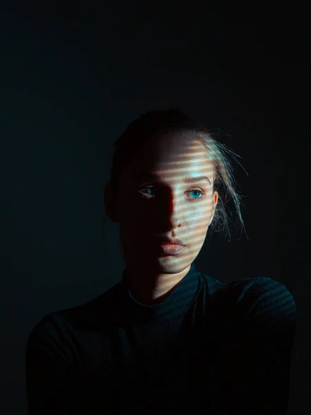 Студийный портрет молодой красивой девушки с тенями на черном фоне — стоковое фото