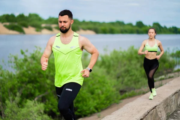 Молодий хлопець і дівчина в стильному спортивному одязі на тренуванні на відкритому повітрі, здоровий активний спосіб життя — стокове фото