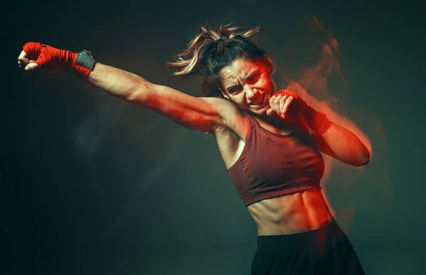 Treinamento feminino esportivo em roupas esportivas elegantes em estúdio. Esporte feminino luta treino. Longa exposição tiro — Fotografia de Stock