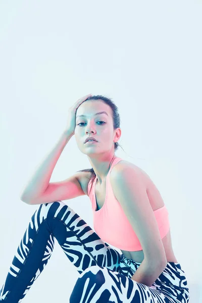 Retrato de joven morena atlética en ropa deportiva posando en estudio en luz de neón —  Fotos de Stock