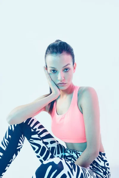 Esportivo jovem ajuste menina no elegante feminino sportswear para exercitar posando em luz de néon, close up studio portrait — Fotografia de Stock