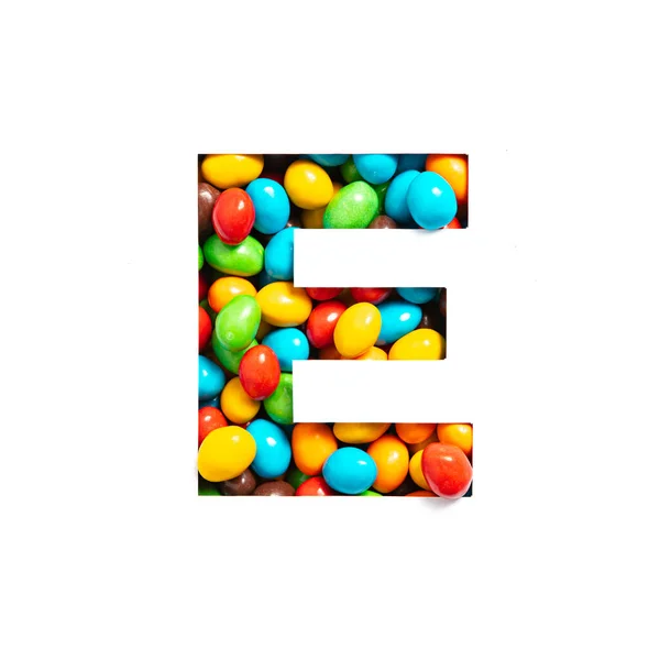 Huruf E dari abjad Inggris dari permen berwarna-warni dan potongan kertas diisolasi dengan warna putih. Jenis huruf untuk desain anak-anak yang meriah — Stok Foto