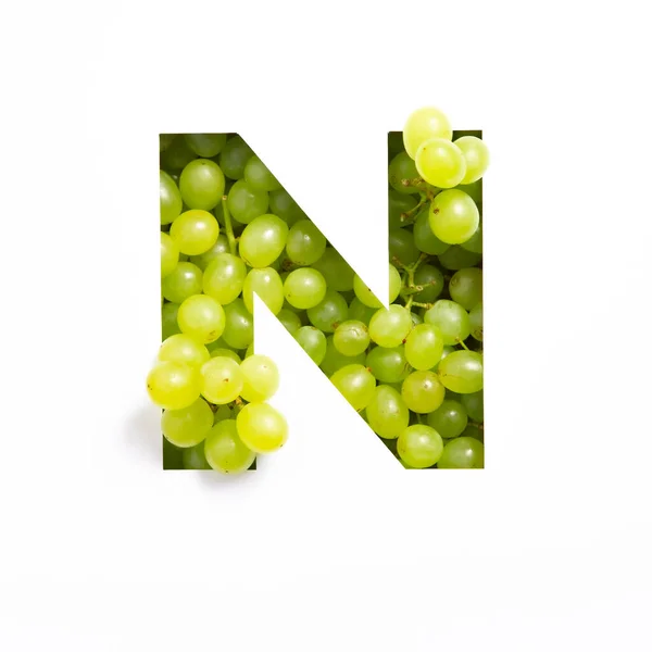 Brief N van het Engelse alfabet van verse druiven en gesneden papier geïsoleerd op wit. Typeface voor ontwerp gemaakt van groene bessen — Stockfoto