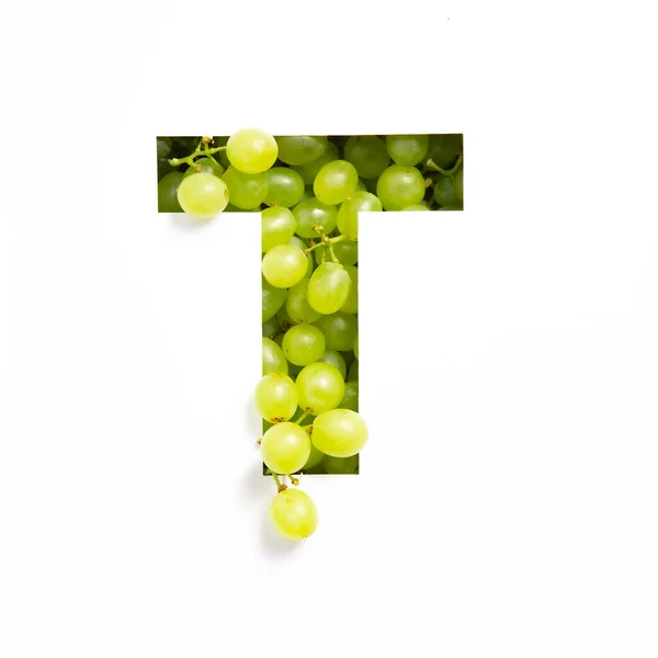 Brief T van het Engelse alfabet van verse druiven en gesneden papier geïsoleerd op wit. Lettertype van groene bessen — Stockfoto