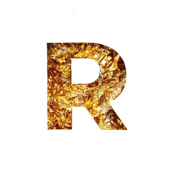 반짝 이는 호일 조각과 종이로 된 영어 알파벳 R 의금 글자가 흰색에서 분리되어 있었다. 변덕 스러운 황금색 서체 — 스톡 사진