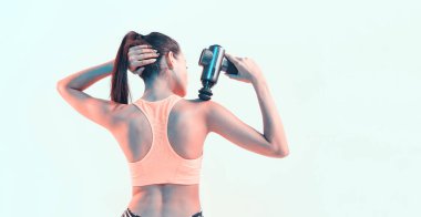 Perküsyon masaj aleti, spor genç esmer kadın masaj stüdyo ışığı altında omuz, eklem ağrısı için terapi.