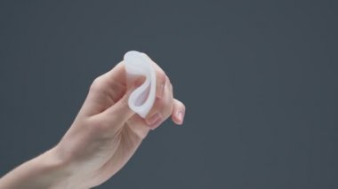 Beyaz yumuşak regl bardağı kadın eliyle sıkışıyor. Alternatif kadın hijyen ürünü. Sıfır atık