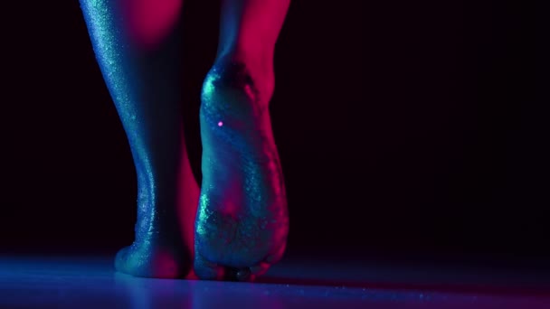 Kvinnlig fot i glittrande glitter rais upp och vända i neon studio ljus, blank kropp konst — Stockvideo