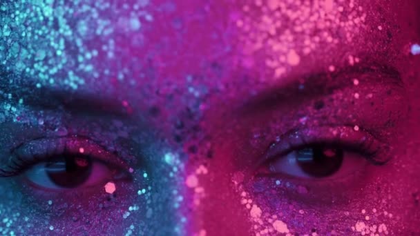 Kvinnliga ögon blinkar under neonblått rosa ljus. Flicka med vacker glittrande makeup, närbild. Begreppet nattliv — Stockvideo