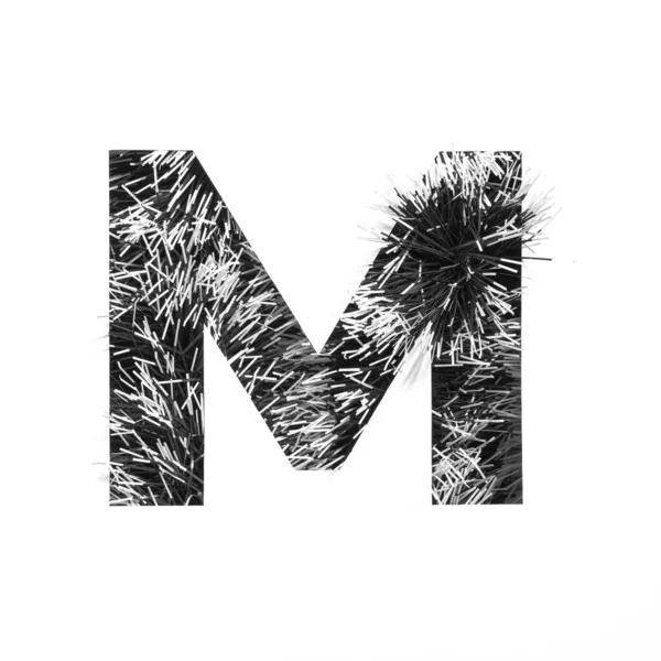 Zwarte letter M van monochrome tinsel en papier gesneden geïsoleerd op wit. Feestelijk Engels alfabet voor minimalistisch design — Stockfoto