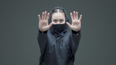 Siyah maskeli kadın kendini savunduğunu gösteriyor ve gidiyor. Cinsiyet ayrımcılığı protestosu, kadın hakları için mücadele