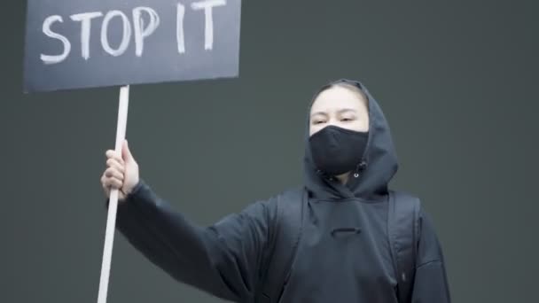 Молода жінка-активістка протестує з картонним знаком, беручи участь у демонстрації. гендерний фемінізм боротьба опором — стокове відео