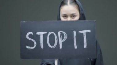 Female protester activist with cardboard sign protesting for social rights, empowerment, women future on gray background
